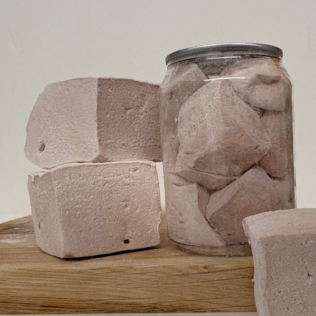 Can filled with Marshmallows on a wooden surface with a neutral background